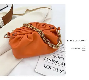 Detailed view of ginger pleated cloud bag with chunky gold chain strap and leather texture