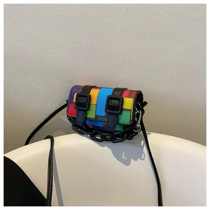 Detail of colorful pixel patchwork mini crossbody bag with black buckles and chunky chain