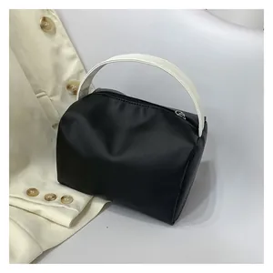 Top view of compact black and white crossbody bag with metal zipper and rounded structure