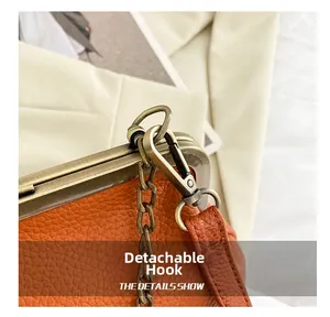 Detail of orange lychee leather handbag with vintage gold metal clasp and detachable hook
