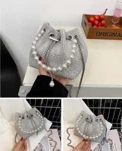 Detailed close-up of a white bucket bag featuring shiny silver rhinestones and a pearl handle