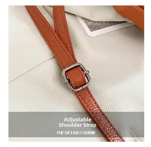 Macro detail of adjustable brown litchi leather strap with premium metal buckle and stitching