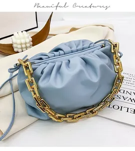 Detail of light blue cloud pouch bag with chunky gold chain strap and soft leather pleats