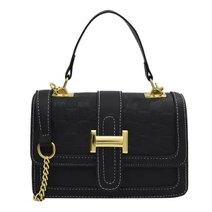 Classic black leather crossbody bag with golden H buckle and textured pattern decoration