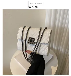 Detailed view of white quilted chain bag with vintage black gemstone square buckle clasp