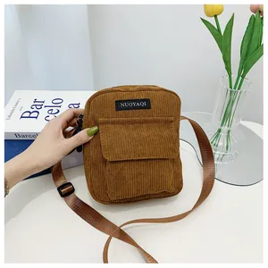 Detailed view of brown corduroy shoulder bag showing fabric texture and brand label