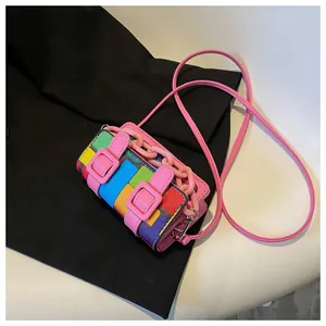 Close-up of multicolor checkered mini bag with pink chain strap and decorative buckles