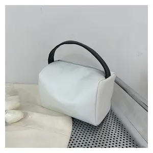 Close-up of white minimalist crossbody bag with black handle and smooth texture details