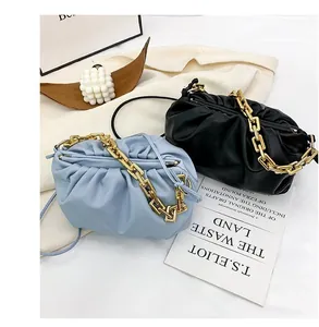 Detail of light blue and black pleated cloud bags with chunky gold metal chains