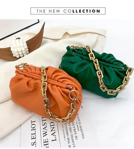Detail of ruched cloud bags with thick gold chain straps in orange and green