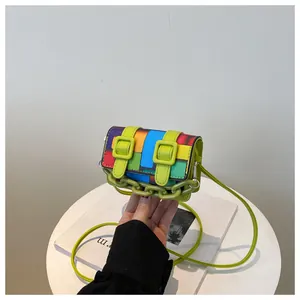 Close-up of mini crossbody bag with vibrant colorful geometric mosaic blocks and green chain