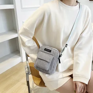 Fashionable grey corduroy crossbody bag with adjustable strap and front flap pocket