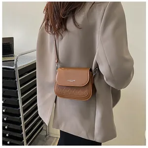 Detail of vintage brown crossbody bag with diamond lattice pattern and fashion text