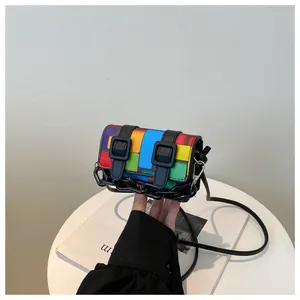Detailed macro view of colorful patchwork mini crossbody bag with black chain and buckled straps