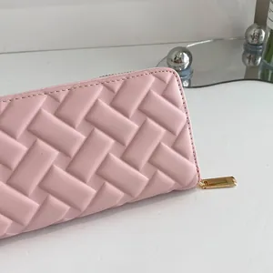 Pink faux leather clutch wallet with 3D woven grid texture and golden zipper