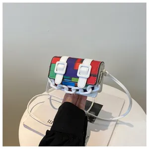 Close-up of a mini crossbody bag with colorful mosaic pattern and white chain detail