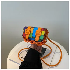Detail of a mini mosaic crossbody bag with colorful geometric patchwork and orange chain