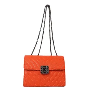 Fashionable orange quilted crossbody bag with metal chain strap and luxury buckle