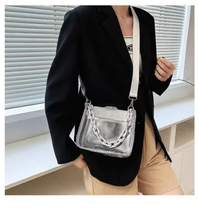 Détail du sac bandoulière transparent en PVC avec bords en strass et large sangle tissée