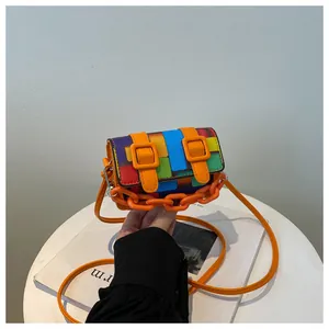 Close-up of mini colorful pixel print bag with bright orange chain and buckle details