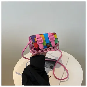 Detail showing mini colorful patchwork crossbody bag with decorative pink chain and strap