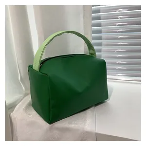 Detailed shot of green PU leather square handbag with smooth zipper and dual-tone handle