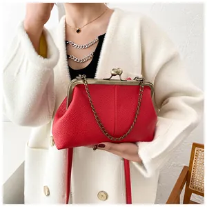 Detail of red vintage shell bag with lychee texture and bronze metal clasp
