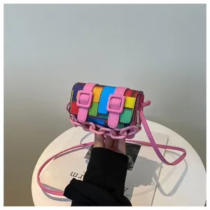 Close-up of vibrant mosaic pattern crossbody bag with pink decorative chain and straps