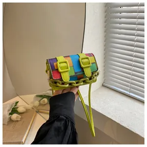 Detail of mini crossbody bag with colorful mosaic pattern and green plastic chain handle