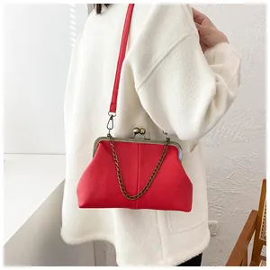 Close-up of red kiss-lock shell bag with lychee texture and vintage metal chain