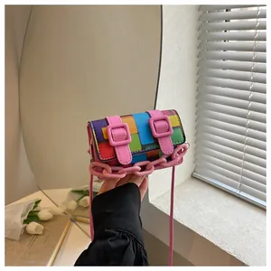 Close-up of pixel style mini crossbody bag with pink chain and colorful grid pattern