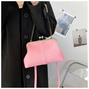 Pink lychee texture shell bag with vintage gold chain strap shown on black coat