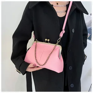 On-model view of a pink litchi texture shell bag with retro clasp and metal chain