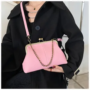 Pink shell bag with litchi grain texture, metal chain and buckle on a black wool coat