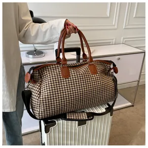 Borsa da viaggio pied de poule con fascia per trolley su valigia bianca