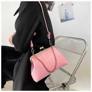 Pink shell bag with litchi texture shown on a black coat for a crossbody style