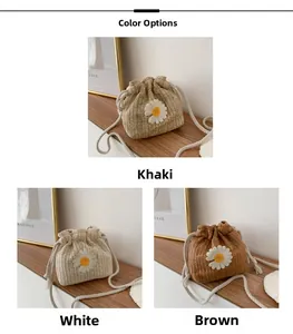 Detail of woven straw bucket bags with daisy patterns and drawstring in three colors