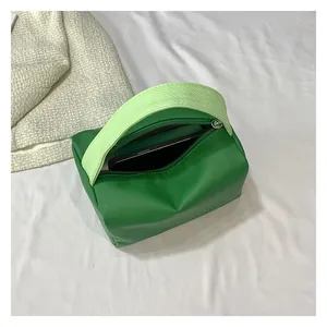 Top view of emerald green mini bag on white fabric showing interior space for smartphone