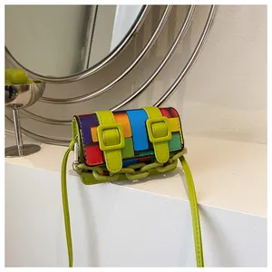 Macro detail of geometric color block mini bag with neon green buckles and plastic chain