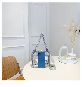 Sac bandoulière transparent orné de strass avec chaîne violette et téléphone pour l'échelle