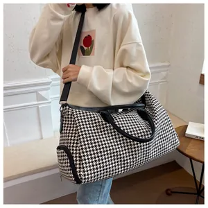Dettaglio di una borsa da viaggio capiente in pied de poule con pratica tasca laterale zip