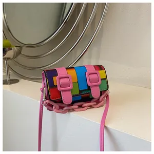 Detail of colorful mosaic mini crossbody bag with pink buckle straps and chain handle