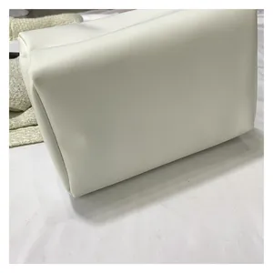 Close-up of white leather square bag detailing soft matte finish and stitching