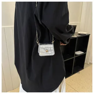 Detail of silver crocodile pattern mini crossbody bag with gold chain and metal buckle