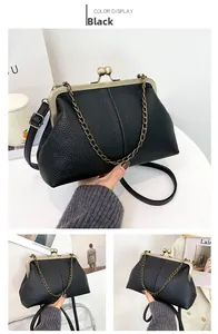 Detail showing litchi texture on black shell bag with golden ball clasp and chains