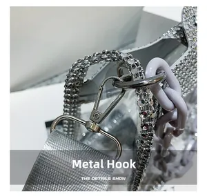 Macro detail of silver metal hook with shiny rhinestone strap and purple chain