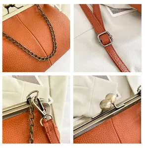 Detail view of orange lychee leather texture and vintage bronze metal clasp on shell bag