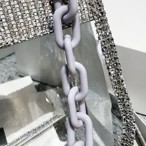 Detailed macro view of sparkling silver rhinestones and purple plastic chain on clear bag