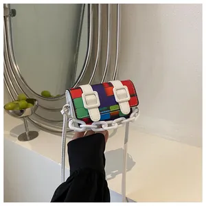 Detail of mini crossbody bag with pixelated color block design and white chain strap