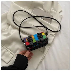 Detail of rainbow mosaic fabric mini bag with black plastic chain and buckle straps